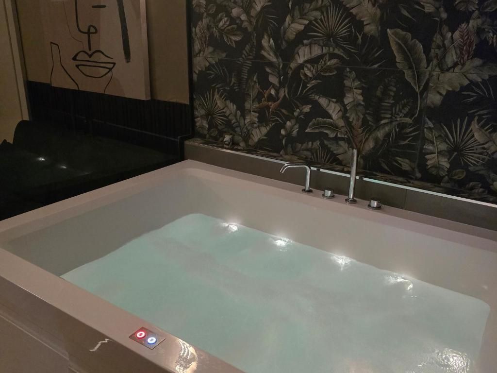 A large, rectangular hot tub with a control panel on the left side.