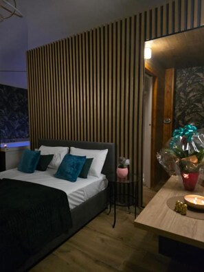 A bedroom with a bed, bedside table, and a wall-mounted light fixture. - Rifugio Borbonico (Portici)