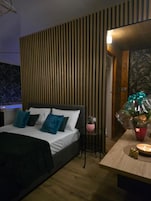 Un dormitorio con cama, mesita de noche y una lámpara de pared.