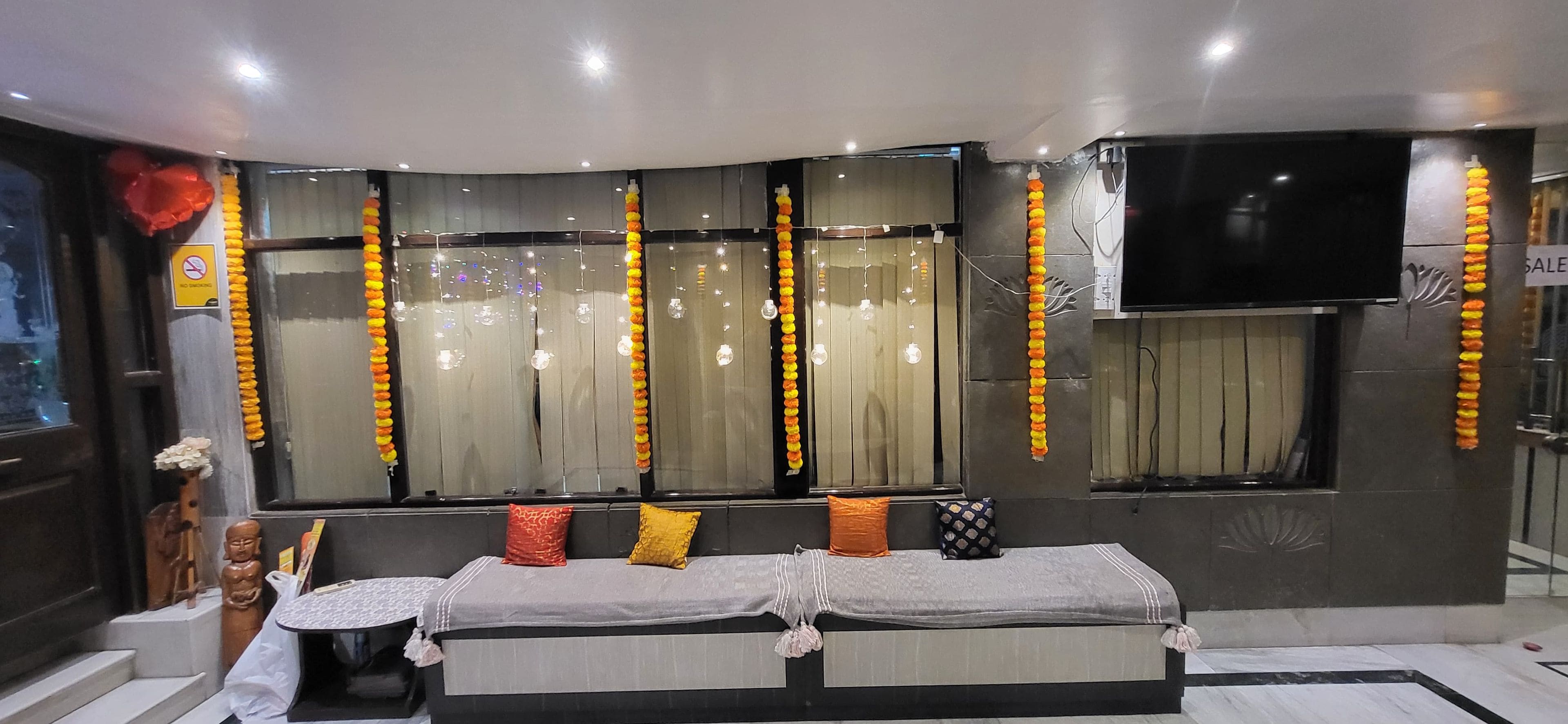 A hotel room with a bed, curtains, a television, and a window.