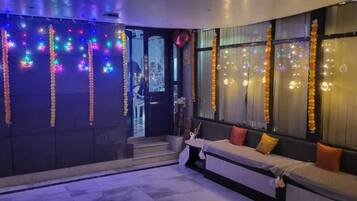 Una habitación con sofá, una mesita y vistas a la ciudad a través de la ventana.