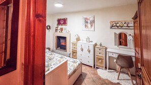 A bedroom with a bed, dresser, desk, and a fireplace. - A Casa di Ayra (Rino)