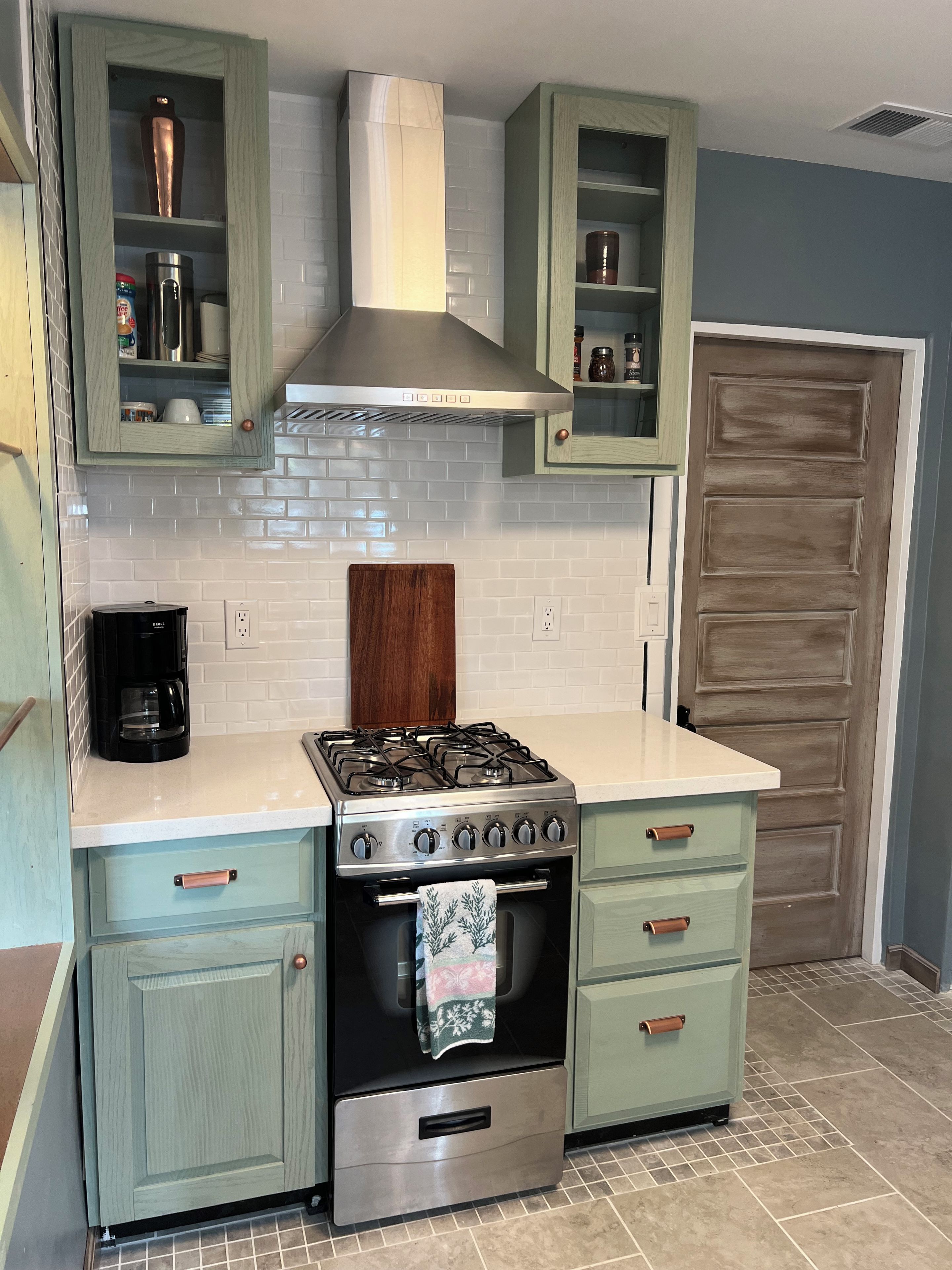 A kitchen with a gas stove, oven, and cabinets.