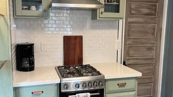 A kitchen with a gas stove, oven, and cabinets.
