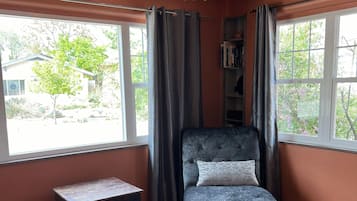 A room with a bed, a small table, and a window with curtains.