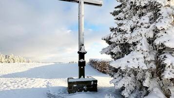 Paesaggio innevato con un monumento a forma di croce.