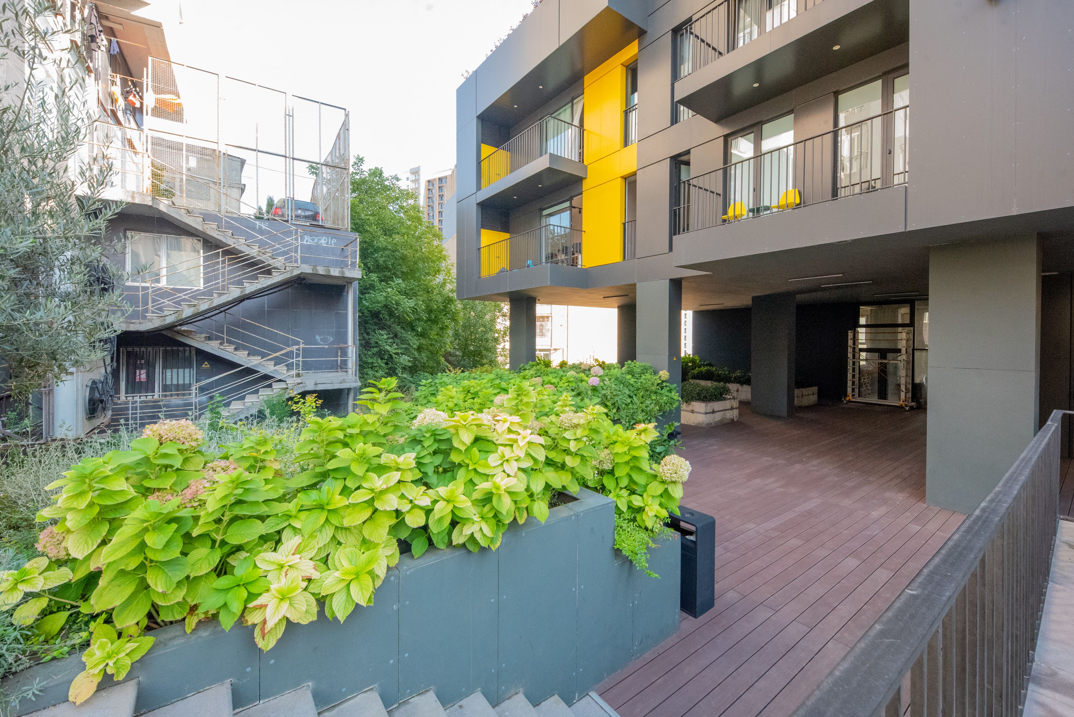 A modern building with a rooftop garden and a staircase leading to an upper level.