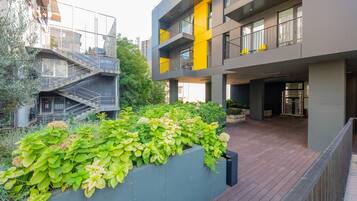 A modern building with a rooftop garden and a staircase leading to an upper level.
