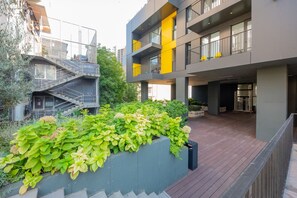 A modern building with a rooftop garden and a staircase leading to an upper level. - HB apartments Chkhikvadze (T'bilisi)