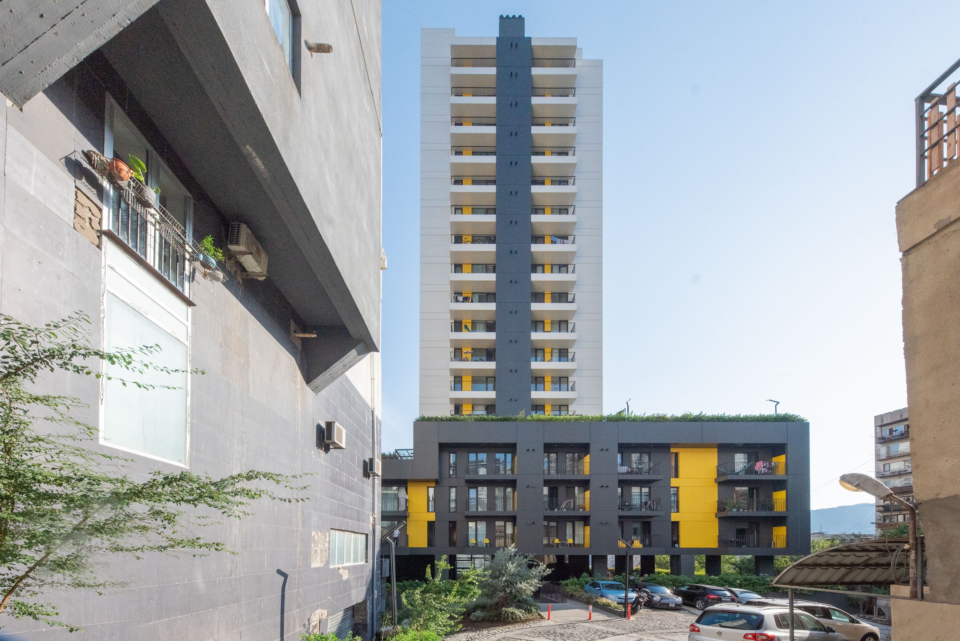 A multi-story building with a modern design, featuring balconies and a mix of window styles.