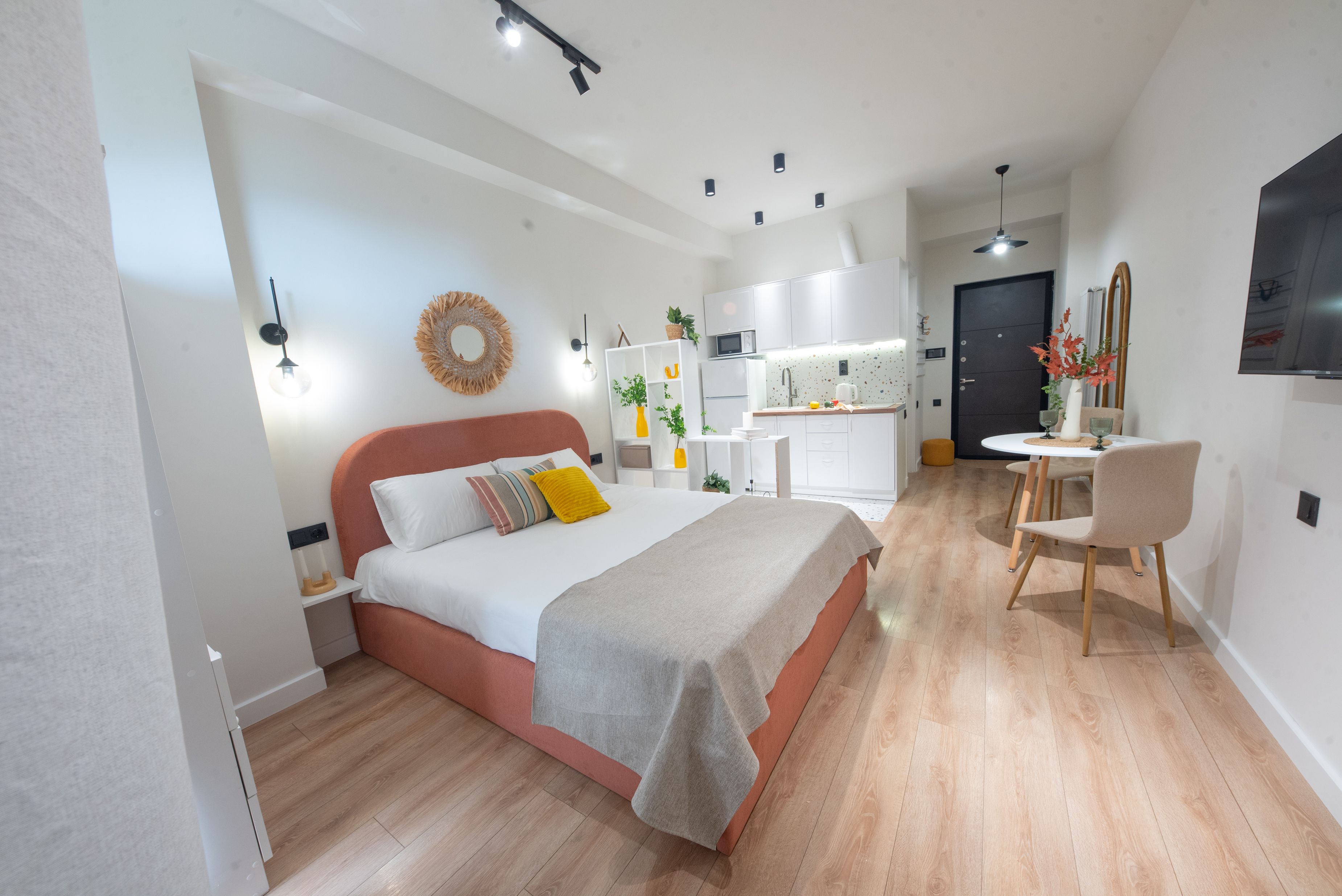 A modern bedroom with a bed, bedside table, and a small seating area with a chair.