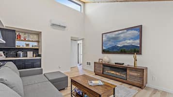 Ein modernes Wohnzimmer mit einer Couch, einem Couchtisch, einem Kamin und einem großen Gemälde an der Wand.