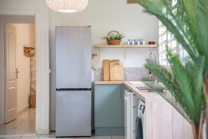 Una cocina moderna con un refrigerador de acero inoxidable, armarios de madera y un lavavajillas integrado.