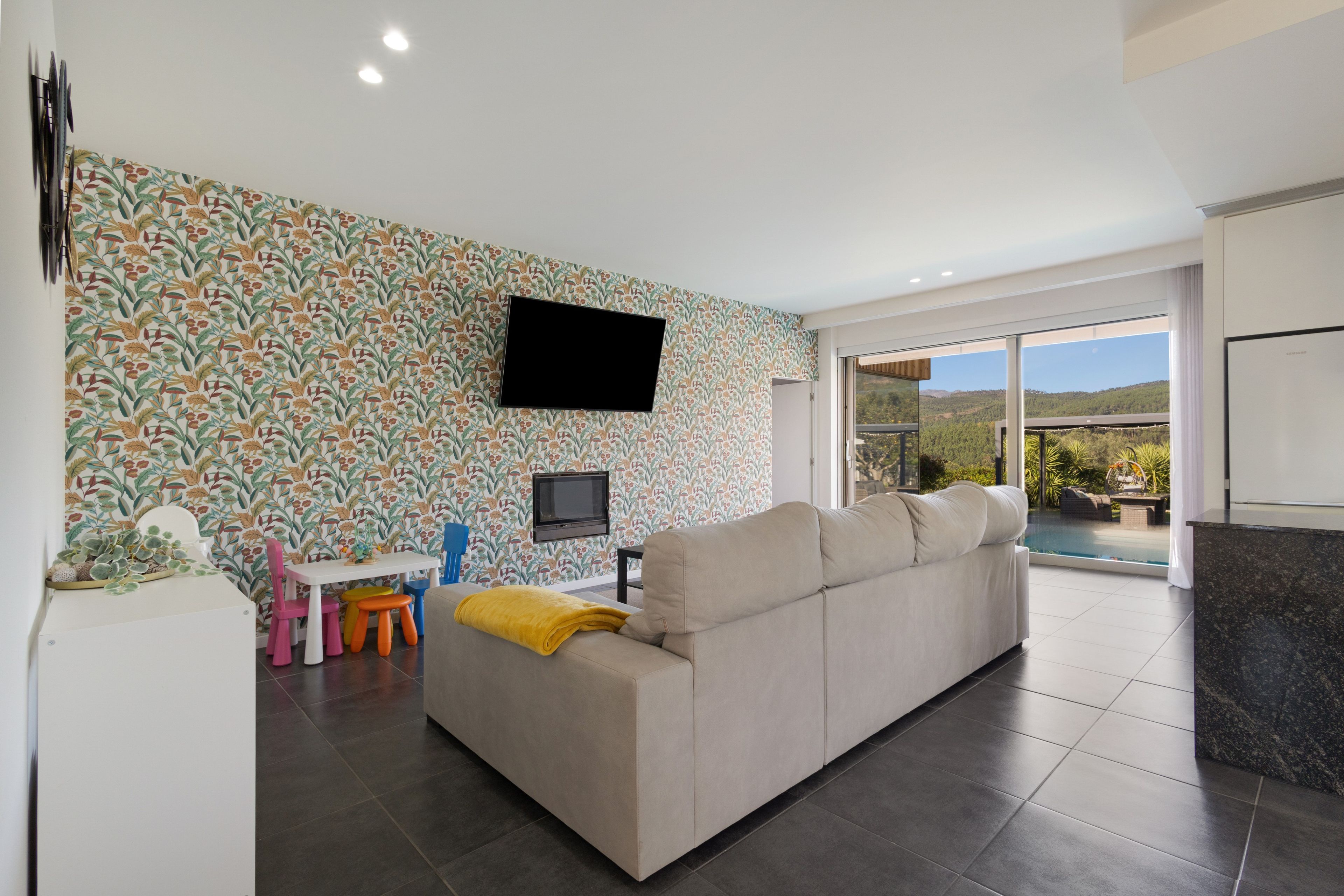 Una sala de estar moderna con un sofá, un televisor de pantalla plana y un comedor con una mesa y sillas.