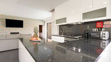 A modern kitchen with a granite countertop, stainless steel appliances, and a white cabinetry.