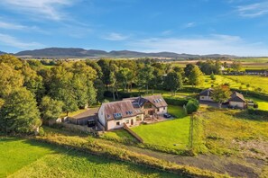 A rural house with a large garden, surrounded by trees and fields. - Schiehallion | Peaceful Scottish Retreat (Blairgowrie)