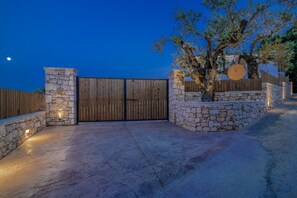 A gated entrance with stone walls and a wooden gate, a tree, and a clear sky. - Villa Verde Zante in Kallithea (Kallithea)