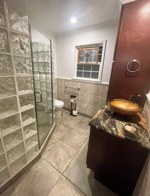 A bathroom with a glass shower enclosure, a toilet, a bidet, and a sink with a decorative bowl. - Welcome to your perfect lakefront getaway! (Avinger)