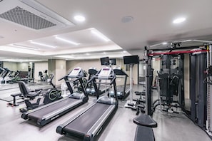 A gym with treadmills, weight machines, and a mirrored wall. - S Class (Seoul)