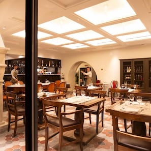 A restaurant with multiple tables and chairs, a bar area, and a ceiling with skylights. - Casa Bianconi (Norcia)