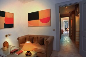 A living room with a sofa, a lamp, and two abstract paintings on the wall. - Casa Bianconi (Norcia)