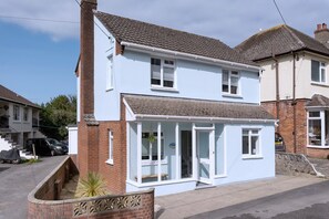 A two-story residential building with a front porch and a garage. - Seaweed (Combe Martin)