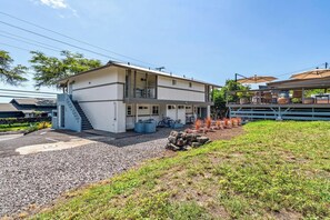 Um edifício de dois andares com varanda, escadaria e entrada pavimentada.