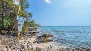 Une zone côtière où un panneau indique que l’accès au bord de mer est libre.