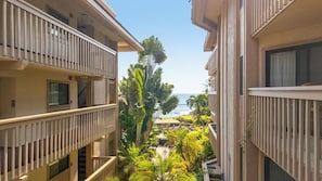 A multi-story hotel with balconies, a pool area, and a view of the ocean. - Royal Kahili Oceanview Condo Sleeps 6 AC + Lanai (Kailua Kona)