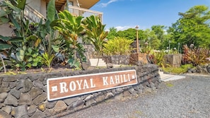 A stone wall with a sign reading 'ROYAL KAHILI.' - Royal Kahili Oceanview Condo Sleeps 6 AC + Lanai (Kailua Kona)