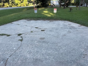 Superficie de hormigón con dos señales que indican 'GUEST PARKING ONLY' y un pavimento agrietado.