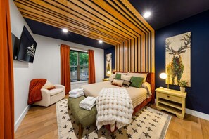 A modern bedroom with a bed, bedside table, and a painting on the wall. - Arden Legacy Retreat: Pool, Sauna, Hot Tub, Game Room, Theater (Avery Creek)