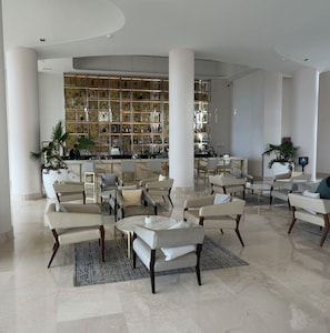 Un hall espacioso con zona de bar, asientos y diseño moderno.