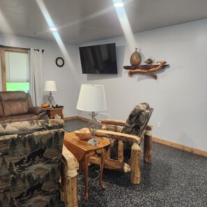 Una sala de estar con un sofá, un sillón y una mesita de centro.