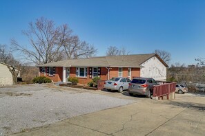 A single-story brick building with a garage, two cars parked in front, and a clear sky. - Group-Ready Nashville Home Near Downtown! (Nashville)