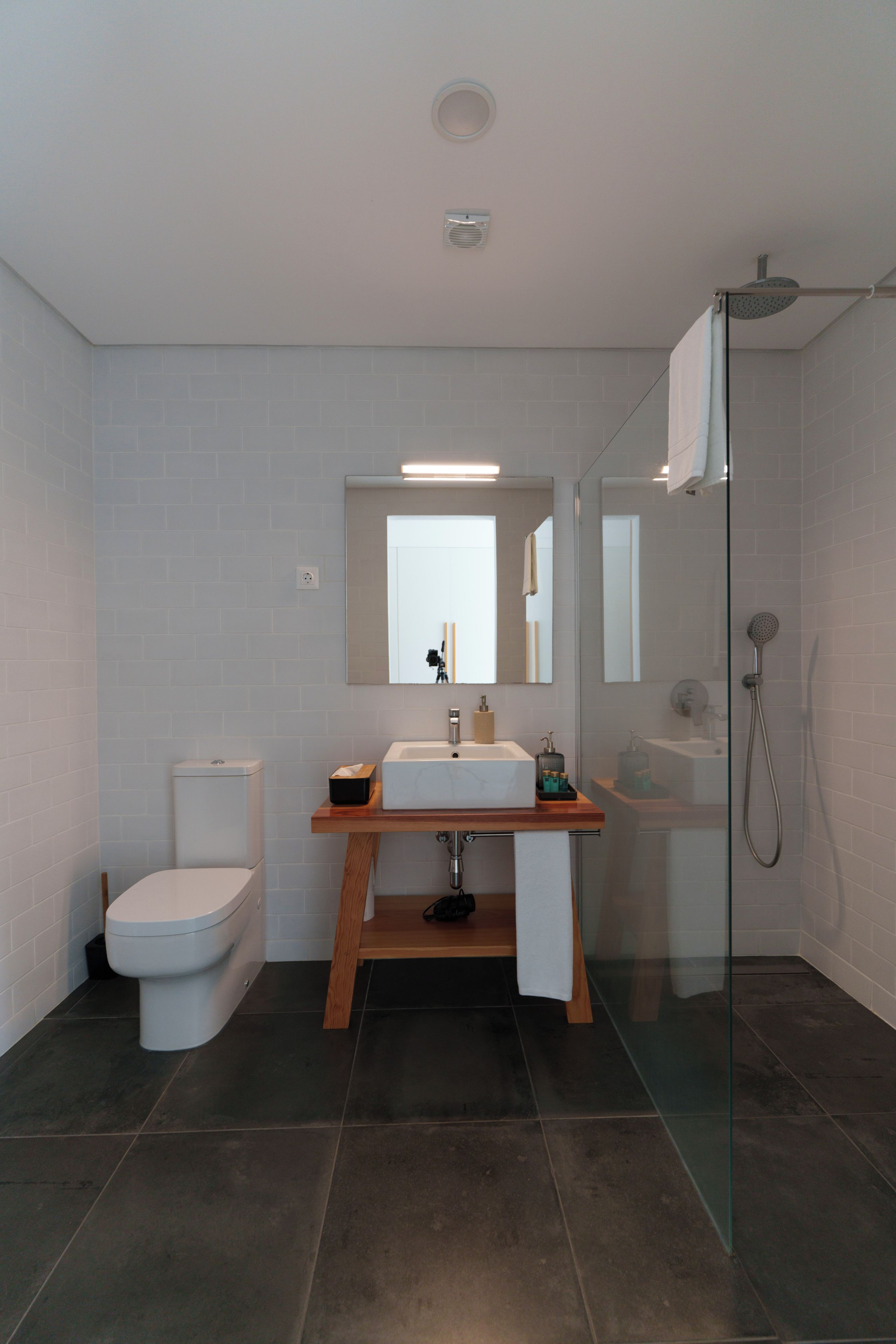A modern bathroom with a toilet, sink, and shower.