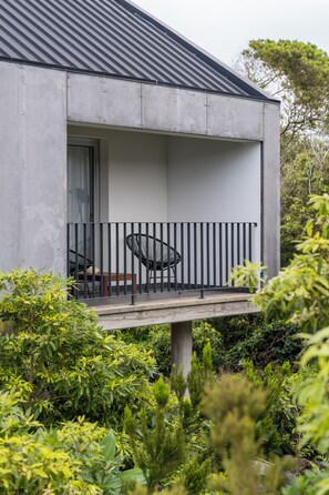 A modern building with a balcony, a chair, and a table.
