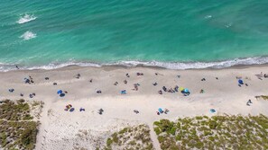 An aerial view of a beach with people and umbrellas. - Sunrise Cove 103: Ground Floor Waterfront Condo on Siesta Key w/ Sleeper Sofa (Sarasota)
