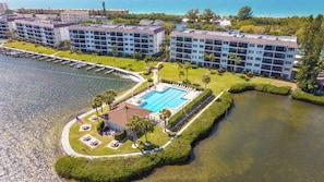 A hotel with a swimming pool, a dock, and a view of the ocean. - Sunrise Cove 108: Ground floor Waterfront Condo on Siesta Key w/ Sleeper Sofa (Sarasota)