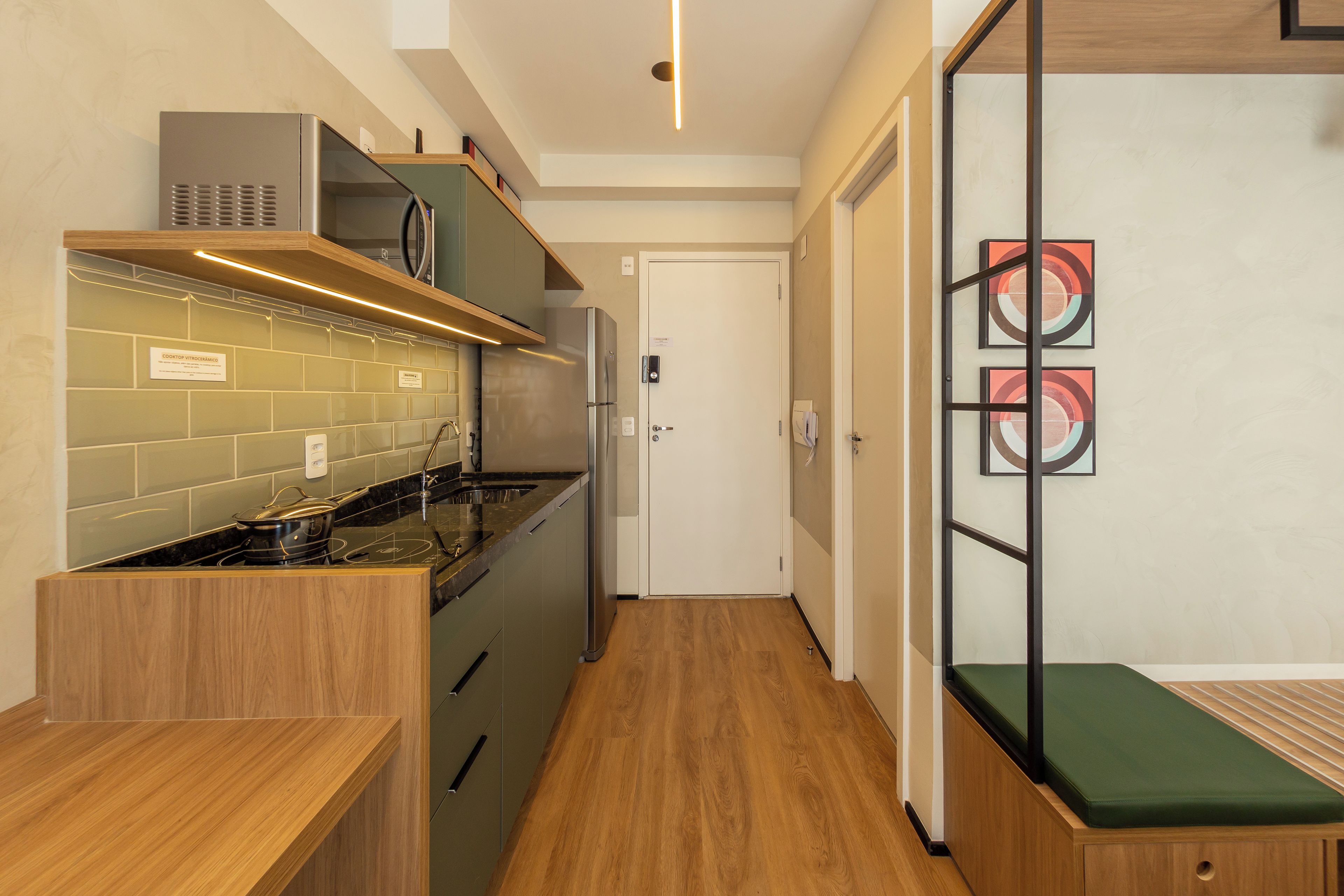 A compact kitchen with a stove, microwave, and wooden cabinets.