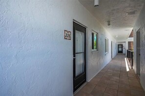 Een gang met deuren voorzien van nummers, die uitkomen op afzonderlijke kamers.