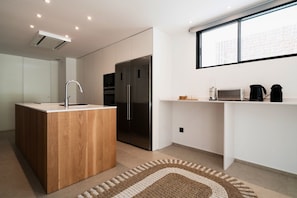 Een moderne keuken met een houten kookeiland, roestvrijstalen apparatuur en een raam met uitzicht op de stad.