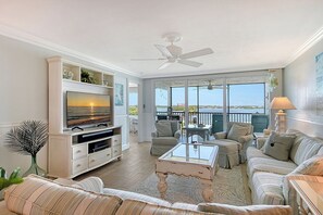 Un salon équipé d’un téléviseur, de canapés, d’une table basse et d’un balcon avec vue.