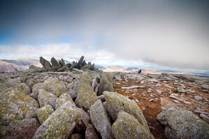 Un paisaje rocoso con grandes rocas y una persona de pie a lo lejos.