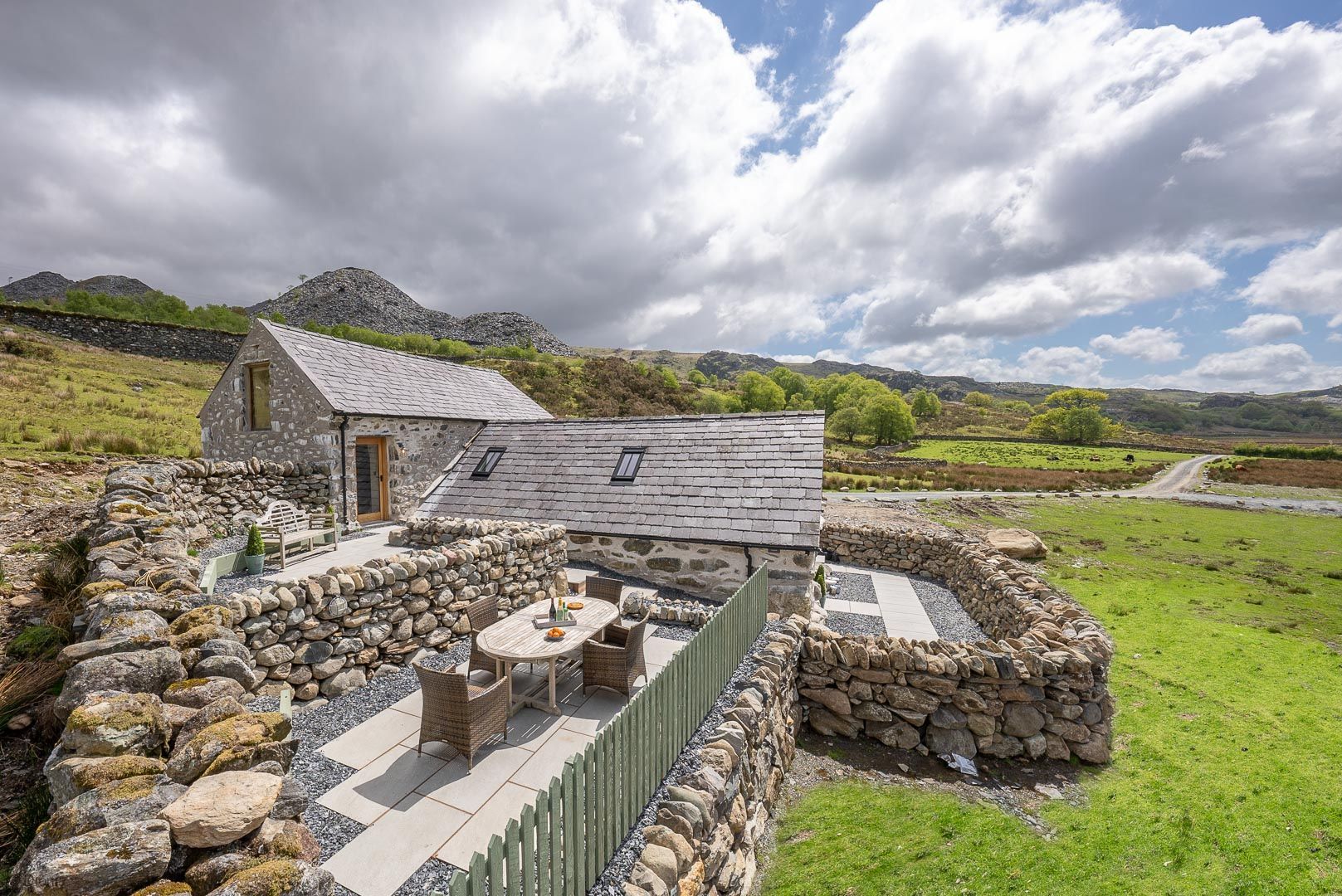 A stone house with a patio and outdoor seating area.
