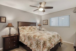A bedroom with a bed, two bedside tables, a ceiling fan, and a window with blinds. - Sunrise Cove 311: Remodeled Waterfront Condo on Siesta Key w/ Murphy Bed (Sarasota)