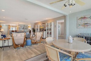 A spacious living area with a dining table, chairs, and a ceiling fan. - Sunrise Cove 425: Spacious Waterfront Condo on Siesta Key with Sleeper Sofa (Sarasota)