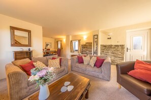 Ein Wohnzimmer mit zwei Sofas, einem Couchtisch und einem Kamin.