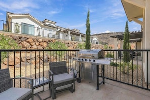 A patio with outdoor furniture and a barbecue grill.