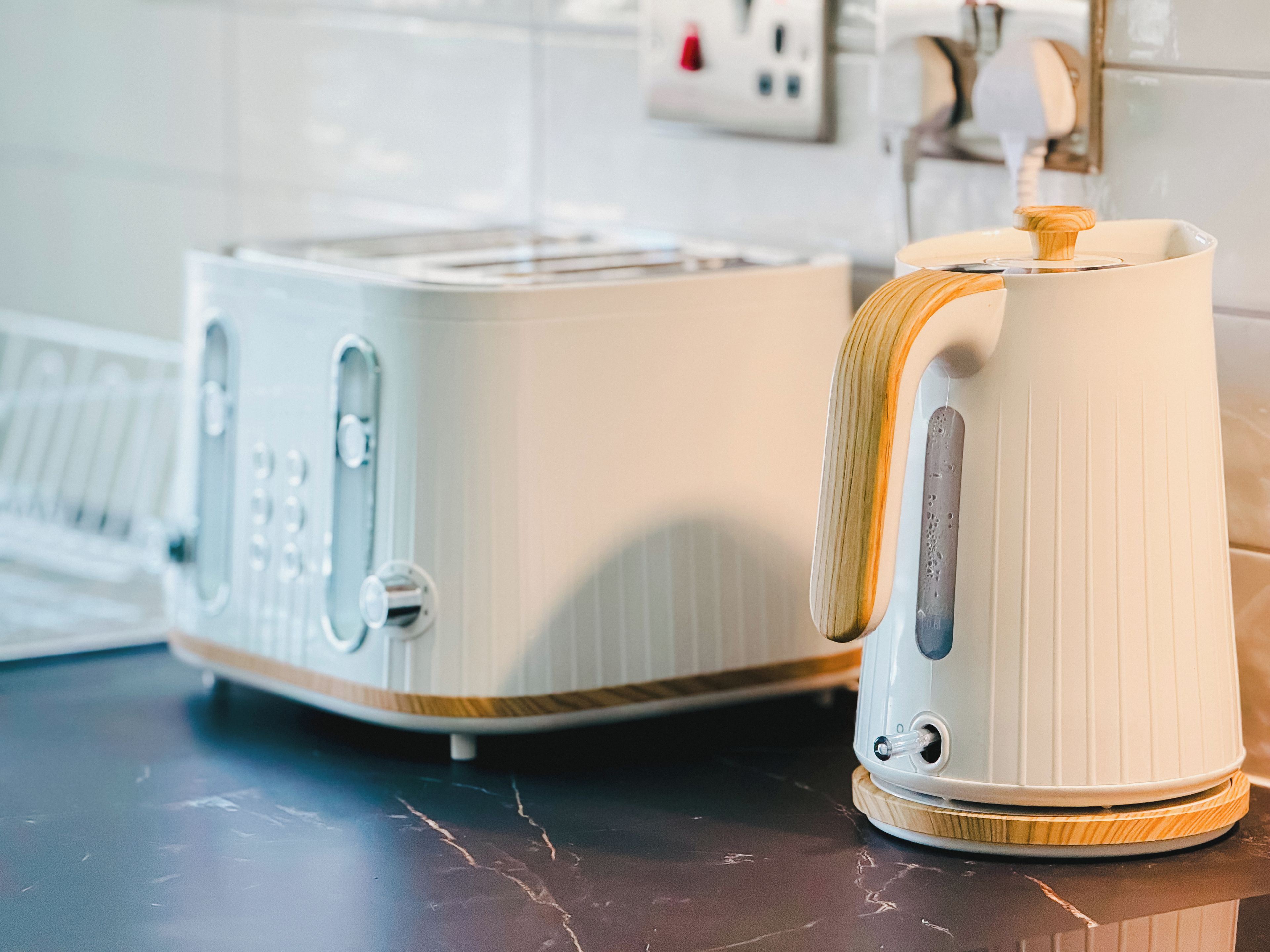 A kitchen with a toaster and a kettle on a countertop.
